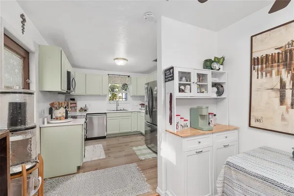 a kitchen with stainless steel appliances white cabinets sink and a granite counter top
