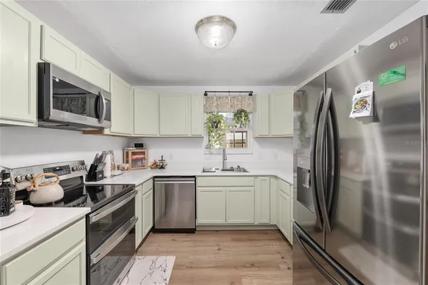 a kitchen with stainless steel appliances a stove microwave and cabinets