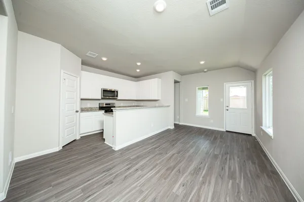 a kitchen with wooden floors and white appliances