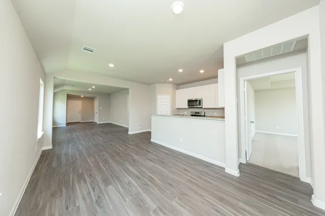 a view of a kitchen with wooden floor and a sink