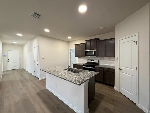 a kitchen with stainless steel appliances granite countertop a sink stove and refrigerator