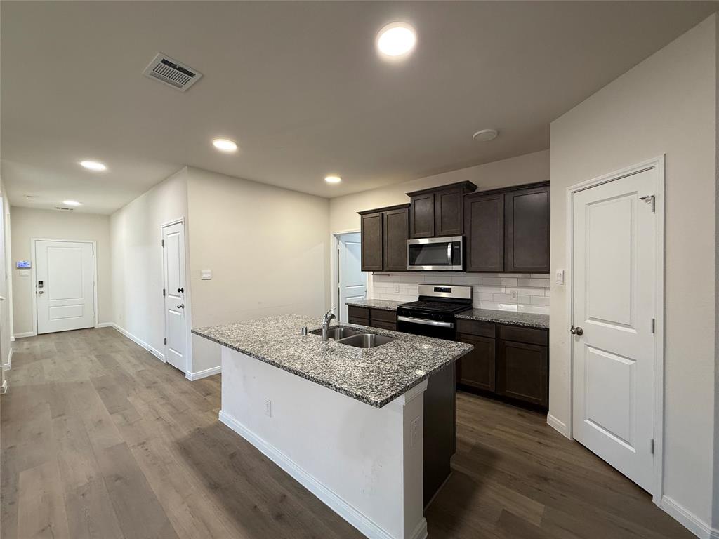 1400 Colonial Bluff Lane Princeton, TX 75407 - Photo 4 of 27 a kitchen with stainless steel appliances granite countertop a sink stove and refrigerator