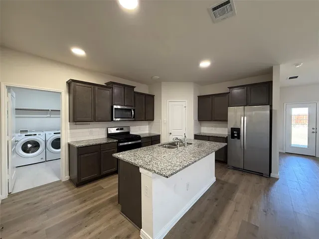 a kitchen with stainless steel appliances granite countertop a sink stove and refrigerator
