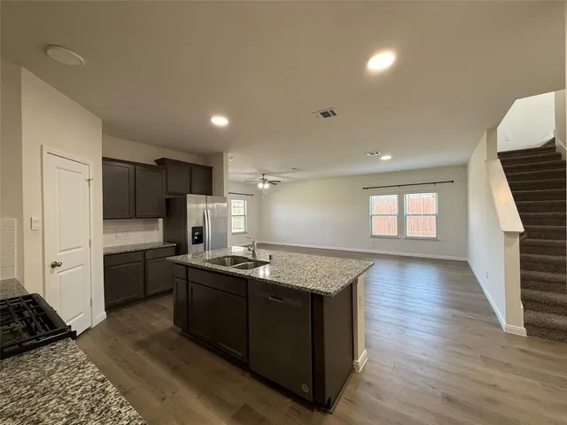 a kitchen with stainless steel appliances granite countertop a stove a sink and a refrigerator