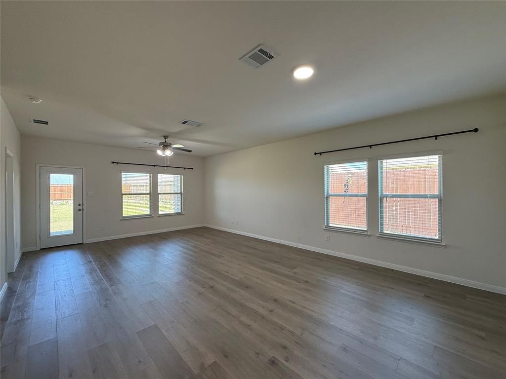 1400 Colonial Bluff Lane Princeton, TX 75407 - Photo 8 of 27 an empty room with wooden floor and windows