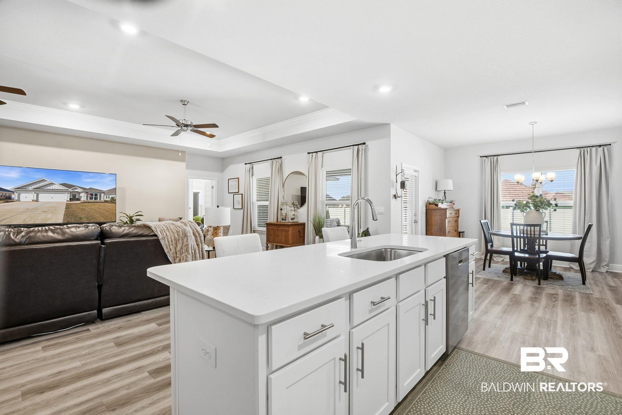 11123 Genuine Risk Circle Daphne, AL 36526 - Photo 66 of 67 Kitchen featuring white cabinets, a raised ceiling, light wood-style floors, light stone counters, and open floor plan