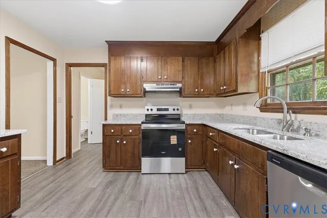 a kitchen with granite countertop wooden floors appliances and sink