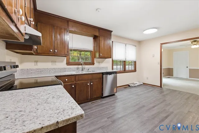 a kitchen with stainless steel appliances granite countertop wooden cabinets a sink and dishwasher
