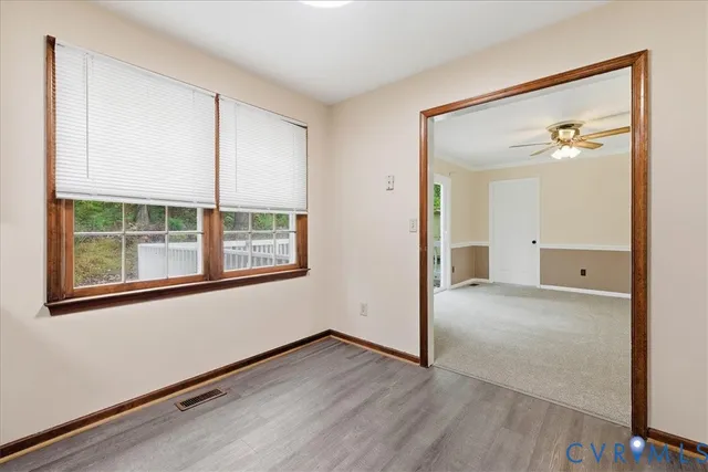 an empty room with a window and wooden floor