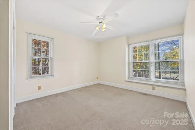 an empty room with window and a ceiling fan