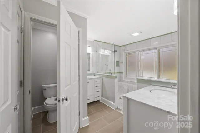 a bathroom with a granite countertop tub sink and mirror