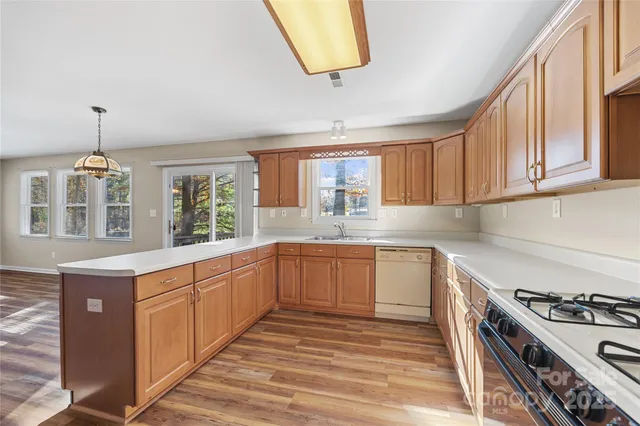 a kitchen with stainless steel appliances granite countertop a refrigerator a stove and a sink with cabinets