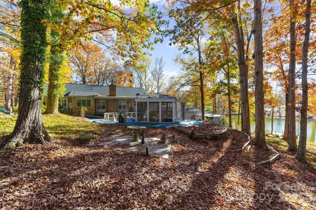 a view of a house with backyard and trees