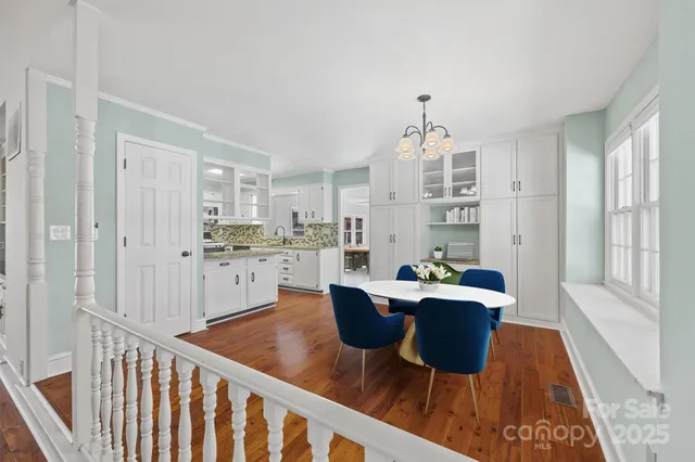 a large white kitchen with granite countertop a large counter top and stainless steel appliances