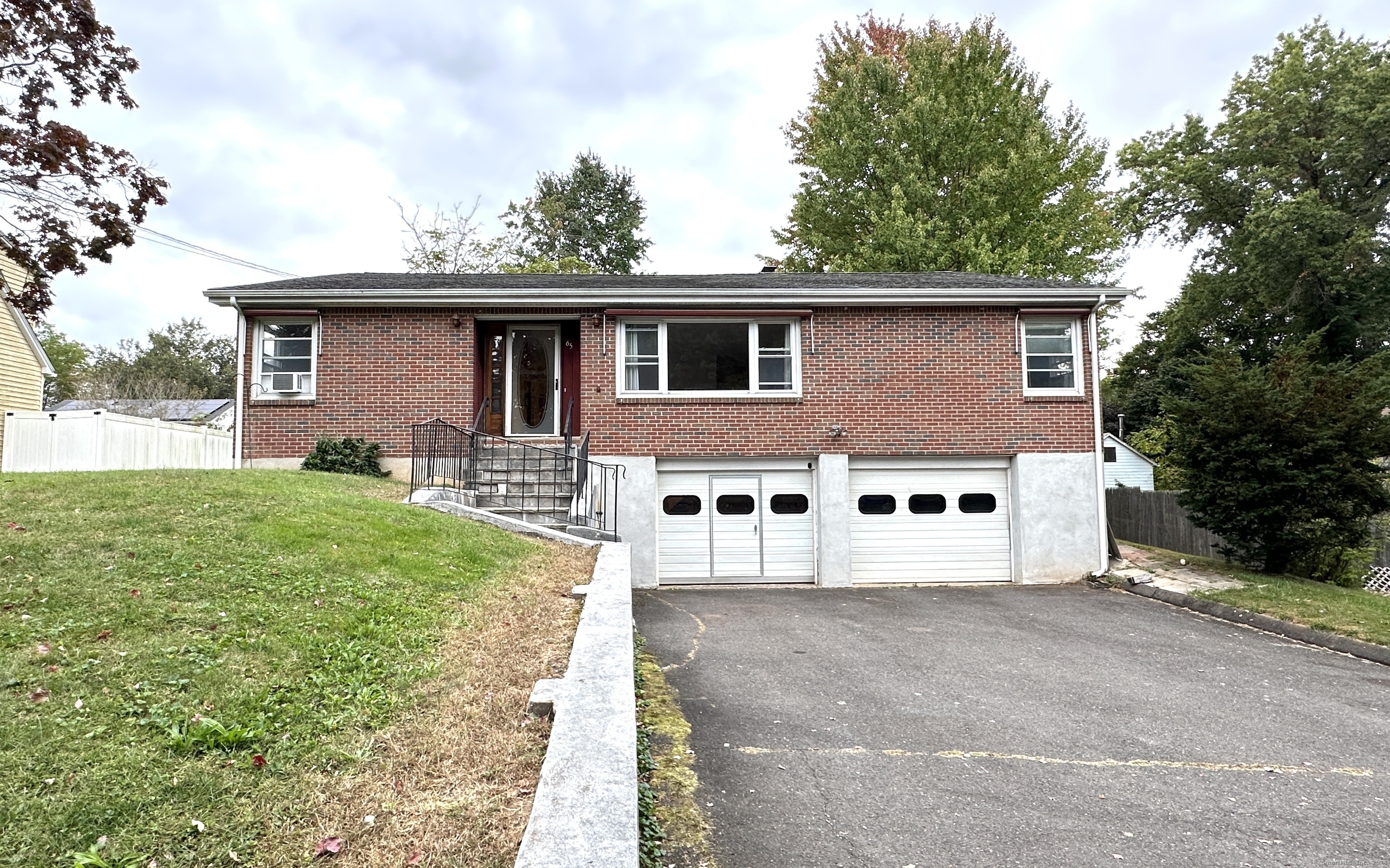 a white house that has tree in front of it