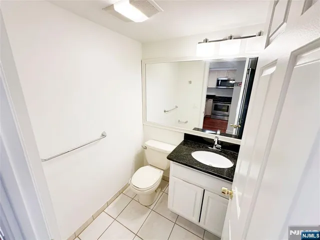 a bathroom with a granite countertop sink and toilet