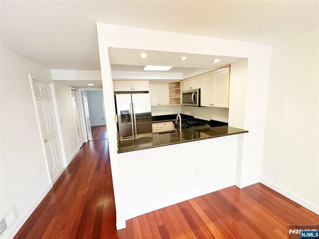 a view of a kitchen with wooden floor and a sink