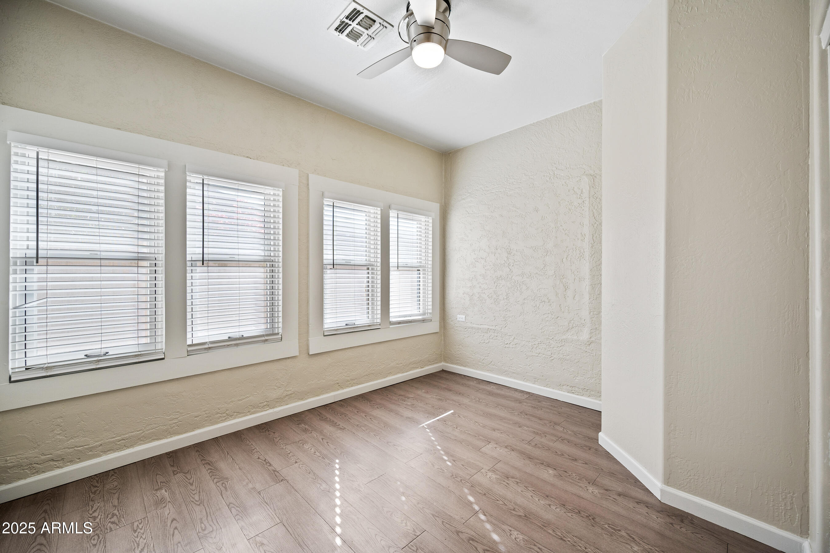 438 North 17th Avenue, Unit B Phoenix, AZ 85007 - Photo 12 of 19 an empty room with wooden floor chandelier fan and windows