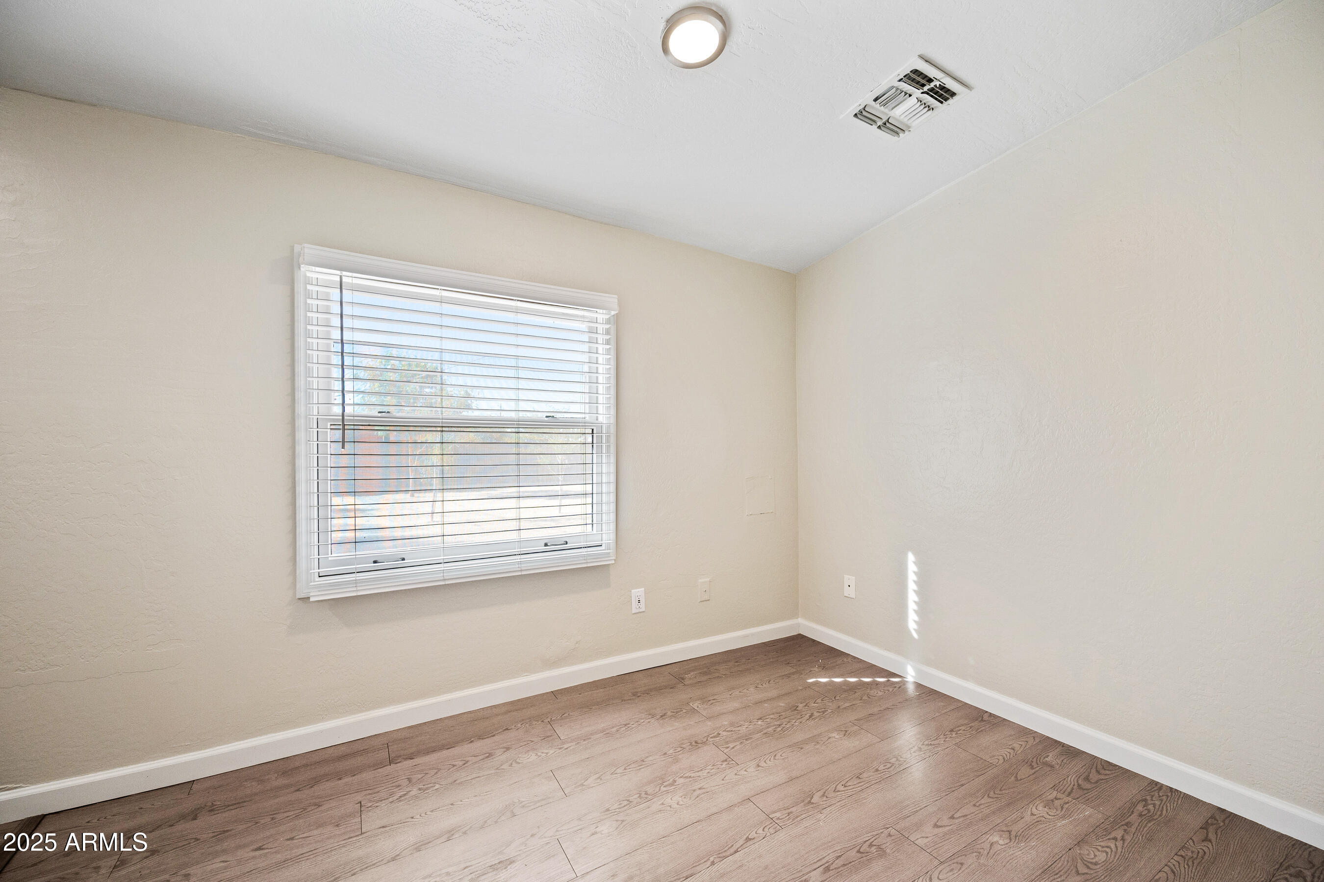 438 North 17th Avenue, Unit B Phoenix, AZ 85007 - Photo 13 of 19 a view of an empty room with wooden floor and a window