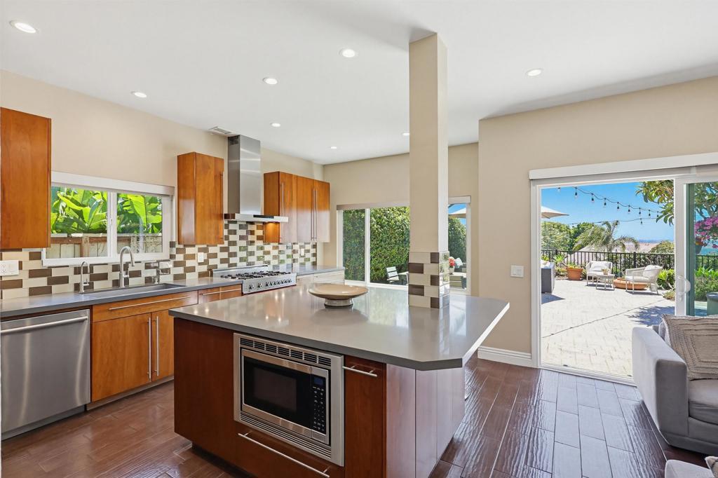 2756 Southampton Road Carlsbad, CA 92010 - Photo 6 of 40 a kitchen with stainless steel appliances granite countertop a sink a stove and a wooden floors