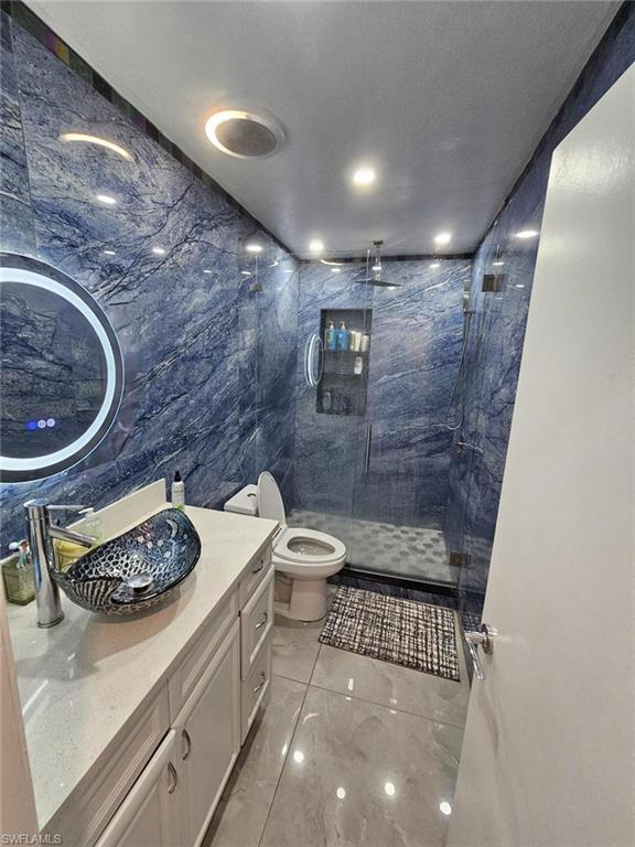 3770 25th Avenue Southwest Naples, FL 34117 - Photo 12 of 15 a bathroom with a granite countertop sink a toilet and a shower