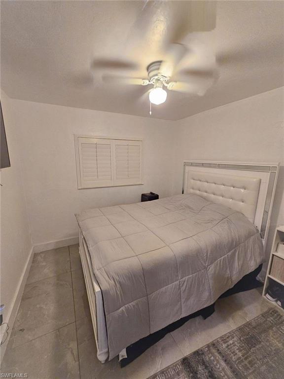 3770 25th Avenue Southwest Naples, FL 34117 - Photo 8 of 15 a bedroom with a bed and a chandelier