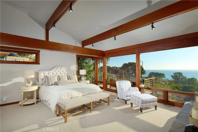 a bedroom with furniture and large windows