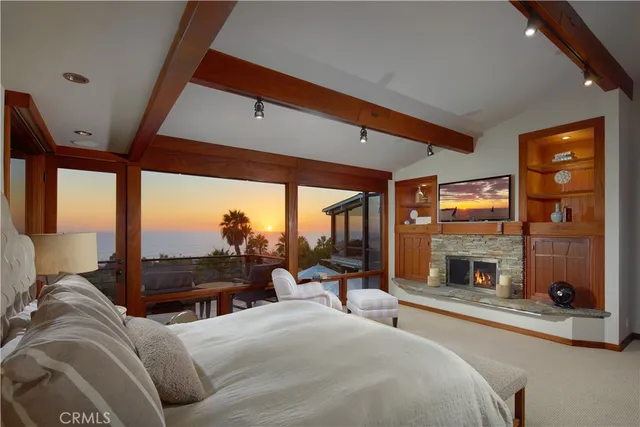 a bedroom with a large bed and a fireplace