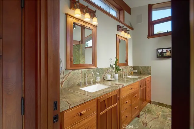 a bathroom with a granite countertop sink and a mirror