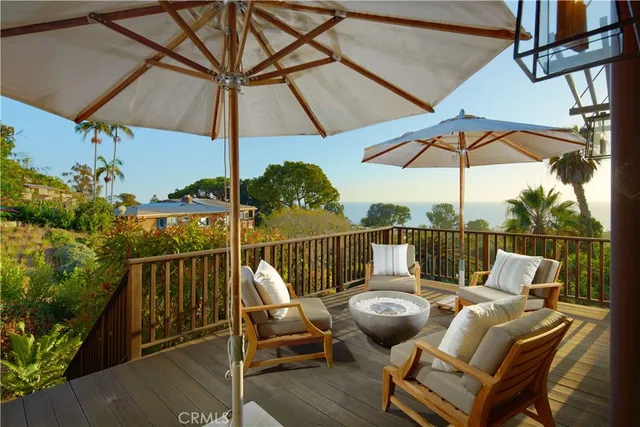 a view of deck with furniture and umbrella