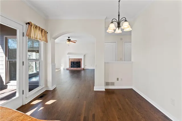 a view of a hallway with a dining table and chairs