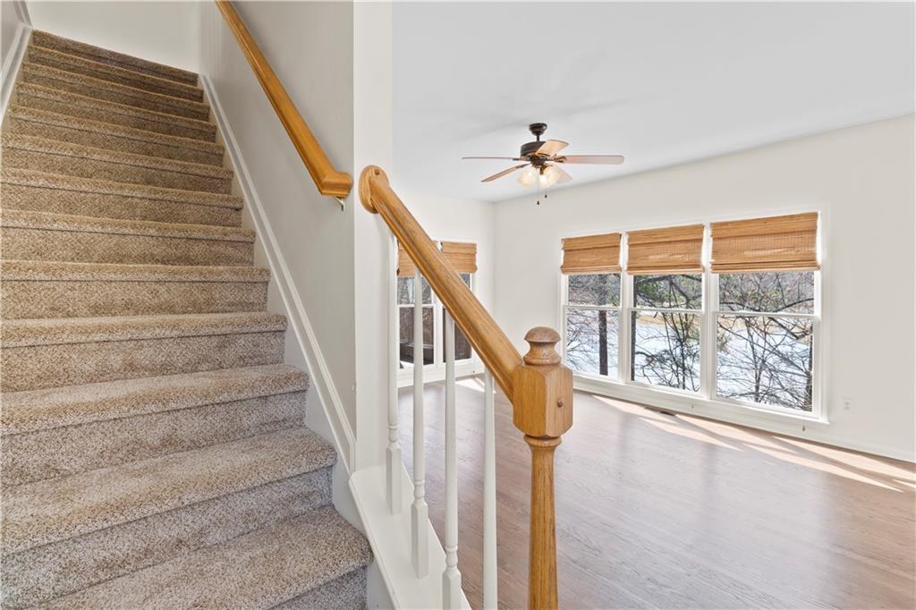325 Morning Mist Walk Suwanee, GA 30024 - Photo 15 of 67 a view of staircase with white walls and a floor to ceiling window