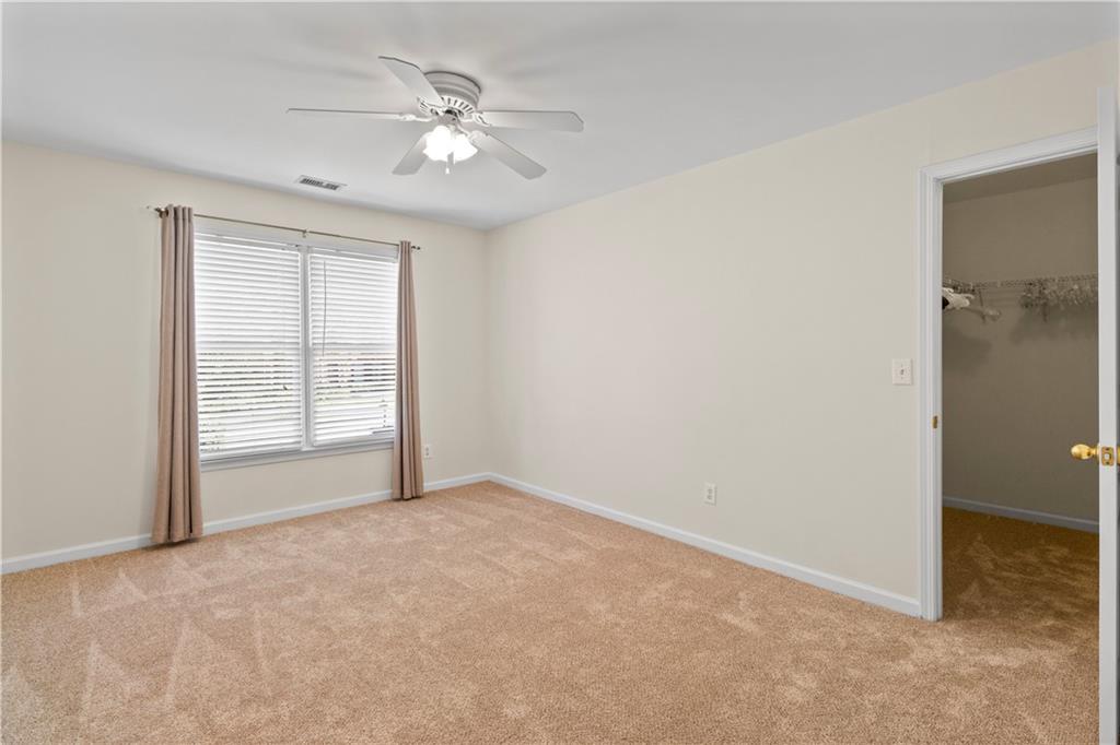 325 Morning Mist Walk Suwanee, GA 30024 - Photo 28 of 67 an empty room with chandelier fan and windows