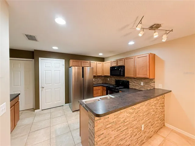 a kitchen with stainless steel appliances granite countertop a sink refrigerator and microwave