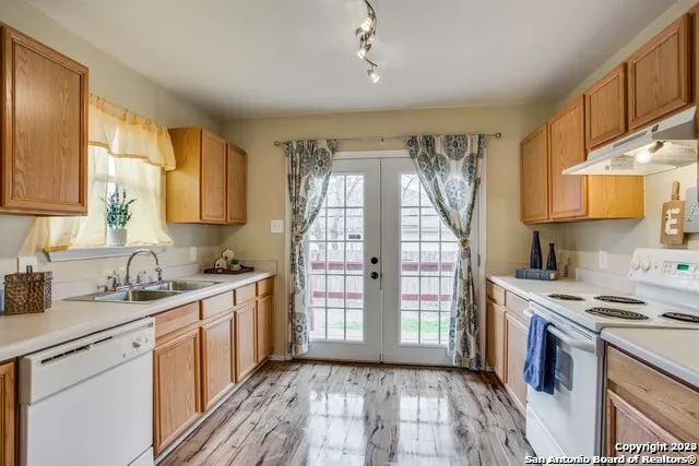 a kitchen with a sink a stove a refrigerator cabinets and a window