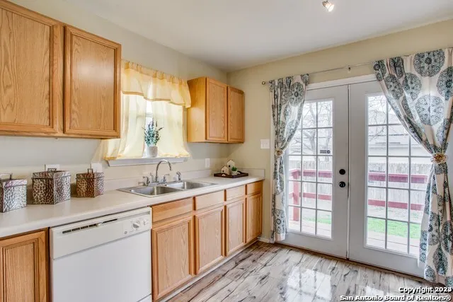 a kitchen with a sink cabinets stainless steel appliances and a window