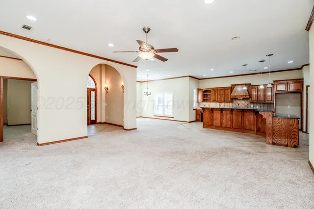 a large kitchen with stainless steel appliances kitchen island granite countertop a large counter top and a view of living room