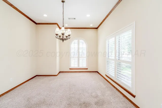an empty room with windows and ceiling fan