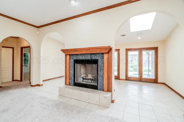 a view of an empty room with a fireplace and a window