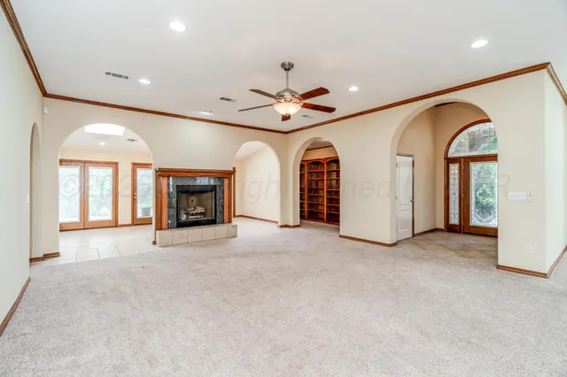 a view of an empty room with a fireplace and a window
