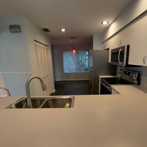 a kitchen with a stove a sink and a refrigerator