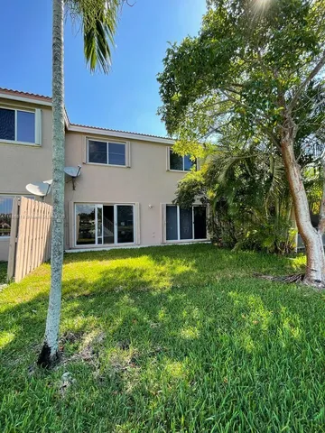 a view of a house with backyard and a tree