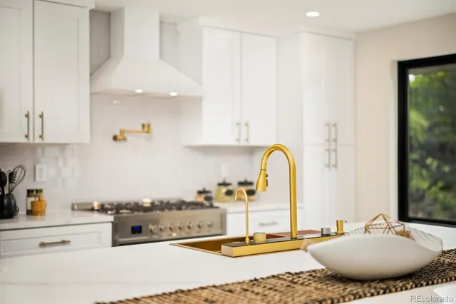 a kitchen with kitchen island granite countertop a stove a sink and a granite counter tops