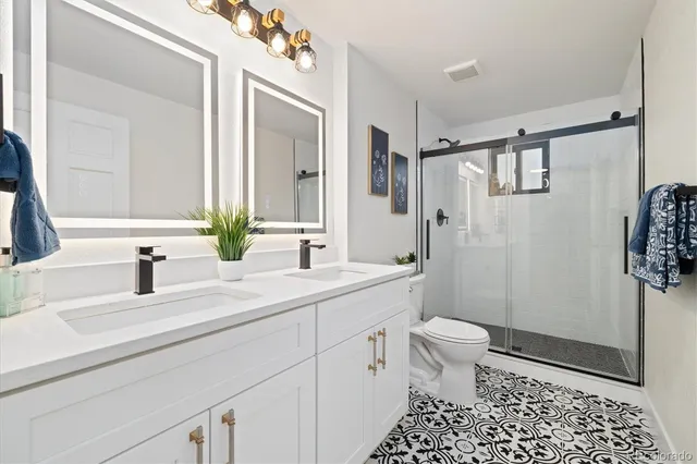 a bathroom with a sink a toilet and shower