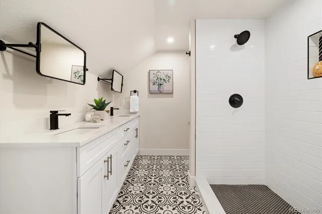 a bathroom with a double vanity sink a mirror a shower and