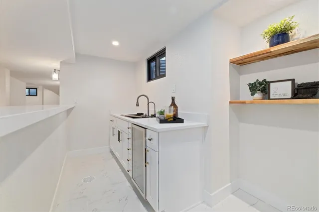 a kitchen with white cabinets a sink and dishwasher