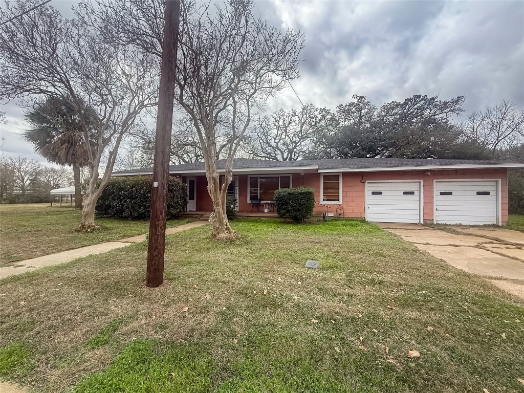 729 Main Street Lexington, TX 78947 - Photo 11 of 15 Ranch-style home with a front lawn, concrete driveway, roof with shingles, and a porch