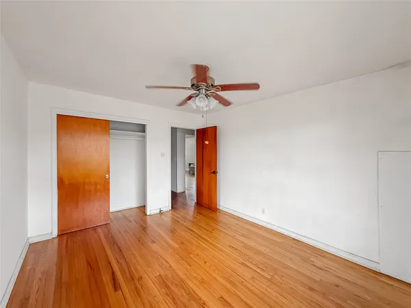 a view of a livingroom with wooden floor and a ceiling fan