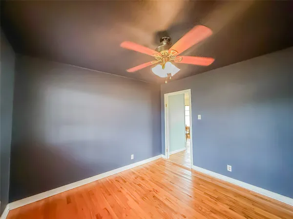 a view of a big room with wooden floor and a chandelier fan