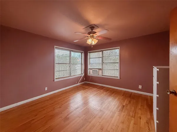 a view of room with window ceiling fan and hardwood floor